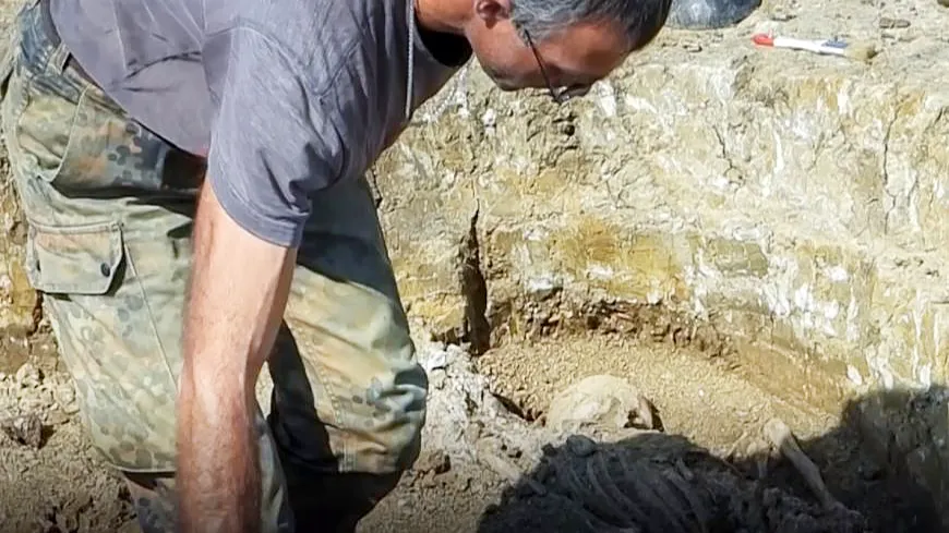 Археолог у вскрытого захоронения