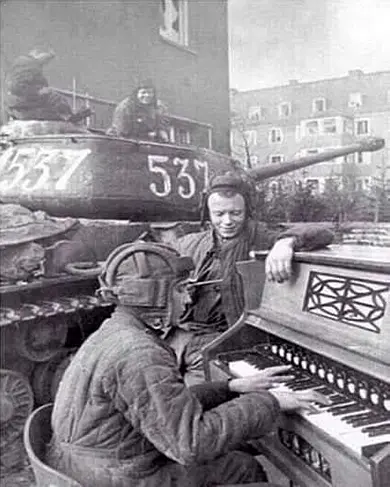советский танкист играет на пианино в поверженном Берлине